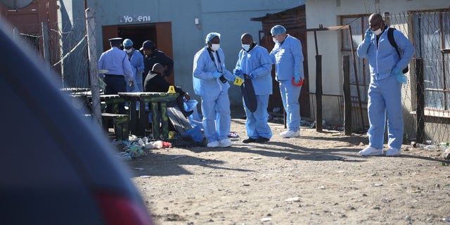 Forensic personnel investigate after the deaths of patrons found inside the Enyobeni Tavern, in Scenery Park, outside East London in the Eastern Cape province, South Africa, June 26, 2022. 