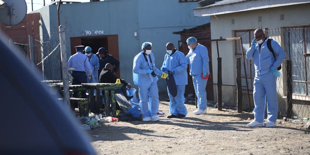 Forensic personnel investigate after the deaths of patrons found inside the Enyobeni Tavern, in Scenery Park, outside East London in the Eastern Cape province, South Africa, June 26, 2022. 