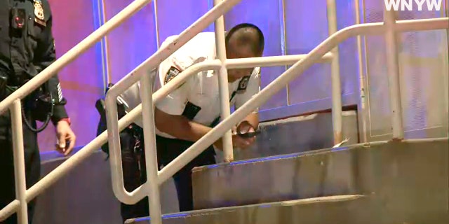 NYPD officials examine a crime scene on the Upper East Side after a woman pushing a baby stroller was shot and killed.