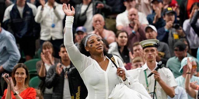 Serena Williams of the US waves as she leaves the court after losing to France's Harmony Tan in a first round women's singles match on day two of the Wimbledon tennis championships in London, Tuesday, June 28, 2022. 