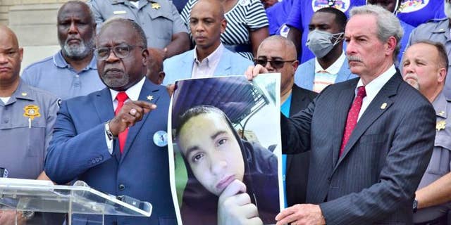Sheriff Leroy Ravenell and SLED director Mark Keel hold up a photo of suspect Michael Lloyd during a press conference on Sunday.