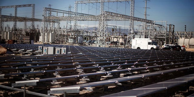 Solar panels are seen next to an electricity station in Carson, California, on March 4, 2022.