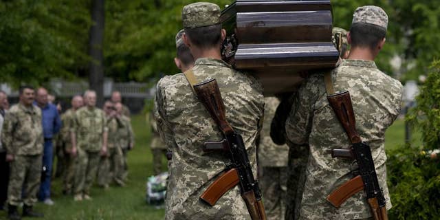 Ukrainian servicemen carry the coffin with the remains of Army Col. Oleksander Makhachek during his funeral in Zhytomyr, Ukraine, on Friday, June 3.