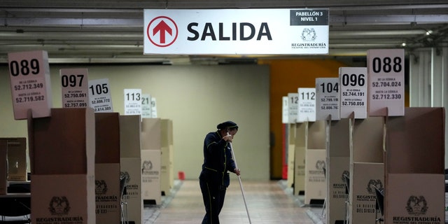 A woman cleans the capital's main voting center in preparation for the presidential runoff election in Bogota, Colombia, Friday, June 17, 2022. Sunday's runoff is between the man who could become the first leftist to lead the nation and a populist millionaire who promises to end corruption. 