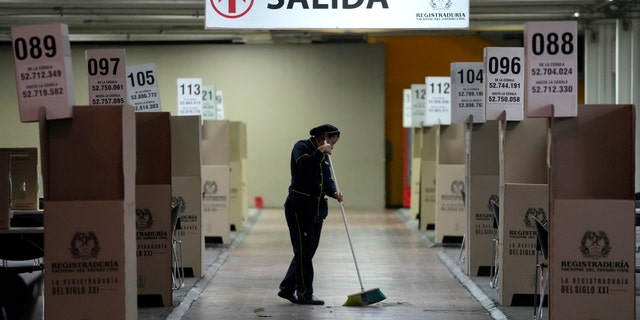 A woman cleans the capital's main voting center in preparation of the presidential runoff election in Bogota, Colombia, Friday, June 17, 2022. (AP Photo/Fernando Vergara)