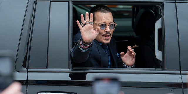 Johnny Depp waves to supporters as he departs the Fairfax County Courthouse Friday, May 27, 2022, in Virginia.
