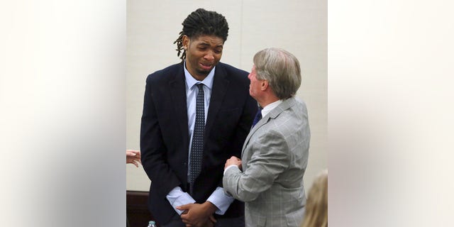 Isimemen Etute, left, and defense attorney Jimmy Turk hug at the conclusion of the trial in Montgomery County Circuit Court Friday, May 27, 2022. 