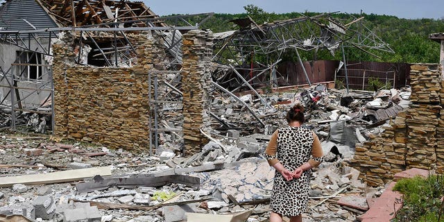 An elderly woman walks next to a building damaged by an overnight missile strike in Sloviansk, Ukraine, Wednesday, June 1, 2022. (G3 Box News Photo/Andriy Andriyenko)