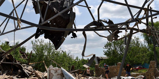 People clean an area of a building damaged by an overnight missile strike in Sloviansk, Ukraine, Wednesday, June 1, 2022. (G3 Box News Photo/Andriy Andriyenko)