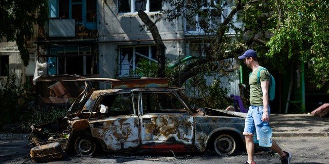 A man walks past an apartment building that was damaged by a missile strike in Sloviansk, Ukraine.