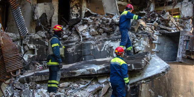 Ukrainian emergency service personnel work outside a damaged building following shelling, in Kharkiv, Ukraine, Saturday, June 4, 2022.