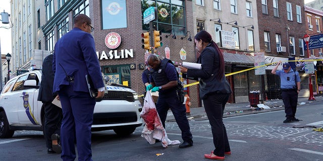 Philadelphia police work the scene of a fatal overnight shooting on South Street in Philadelphia, Sunday, June 5, 2022. Two people have been arrested and charged in the incident and a third is being sought, authorities sad Wednesday. 