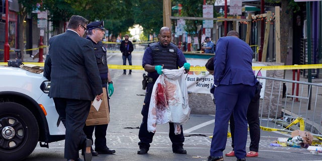 Philadelphia Police investigators work the scene of a fatal overnight shooting on South Street in Philadelphia, Sunday, June 5, 2022. 