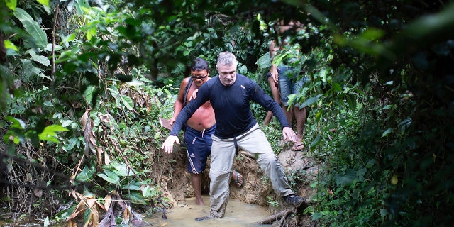 British journalist Dom Phillips, right, and a Yanomami Indigenous man walk in Maloca Papiu village, Roraima state, Brazil, Nov. 2019.
