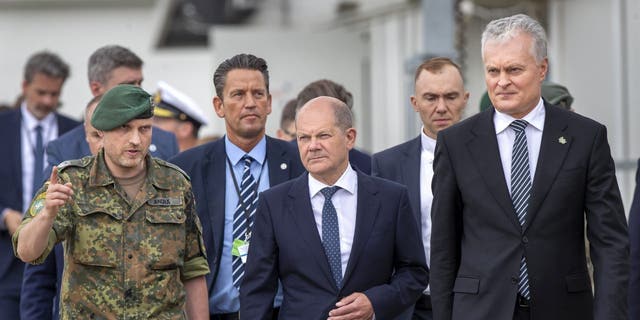 German Chancellor Olaf Scholz, center, speaks with Lieutenant Colonel Daniel Andra, the commander of the multi-national NATO Enhanced Forward Presence (EFP) battalion in Lithuania during a visit at the Training Range in Pabrade, some 60km (38 miles) north of the capital Vilnius, Lithuania, Tuesday, June 7, 2022. 