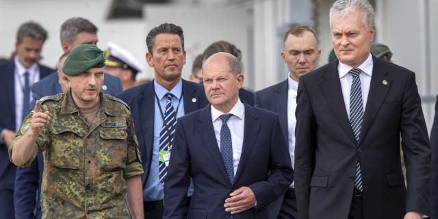 German Chancellor Olaf Scholz, center, speaks with Lieutenant Colonel Daniel Andra, the commander of the multi-national NATO Enhanced Forward Presence (EFP) battalion in Lithuania during a visit at the Training Range in Pabrade, some 60km (38 miles) north of the capital Vilnius, Lithuania, Tuesday, June 7, 2022. 