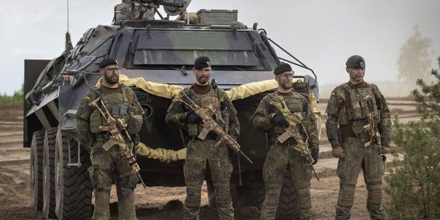 German Bundeswehr soldiers of the NATO enhanced forward presence battalion wait to greet German Chancellor Olaf Scholz upon his arrival at the Training Range in Pabrade, some 60km.(38 miles) north of the capital Vilnius, Lithuania, Tuesday, June 7, 2022.