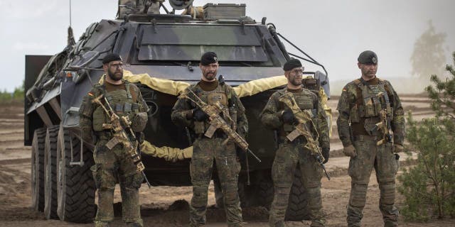 German Bundeswehr soldiers of the NATO enhanced forward presence battalion wait to greet German Chancellor Olaf Scholz upon his arrival at the Training Range in Pabrade, some 60km.(38 miles) north of the capital Vilnius, Lithuania, Tuesday, June 7, 2022.