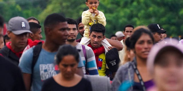 Migrants, mostly from Central America and Venezuela, walk along the Huehuetan highway in the Mexican state of Chiapas on June 7, 2022. 