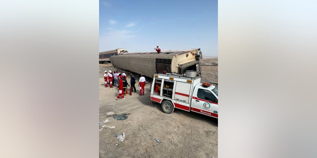 In this photo provided by the Iranian Red Crescent Society, rescuers work at the scene where a passenger train partially derailed near the desert city of Tabas in eastern Iran, Wednesday, Iran, Wednesday, June 8, 2022. (Iranian Red Crescent Society via G3 Box News)
