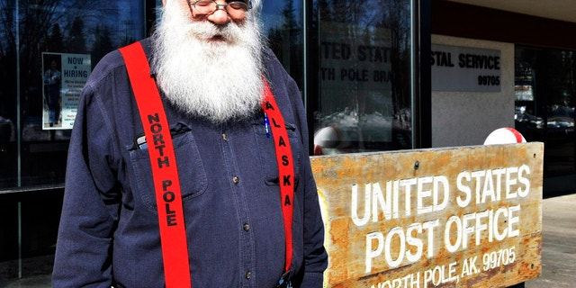 Santa Claus stands in front of the North Pole post office, Sunday, April 24, 2022. A self-described "independent, progressive, democratic socialist" whose legal name is Santa Claus has gotten attention but has not been raising money.  