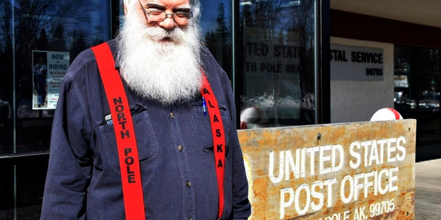 Santa Claus stands in front of the North Pole post office, Sunday, April 24, 2022. A self-described "independent, progressive, democratic socialist" whose legal name is Santa Claus has gotten attention but has not been raising money.  