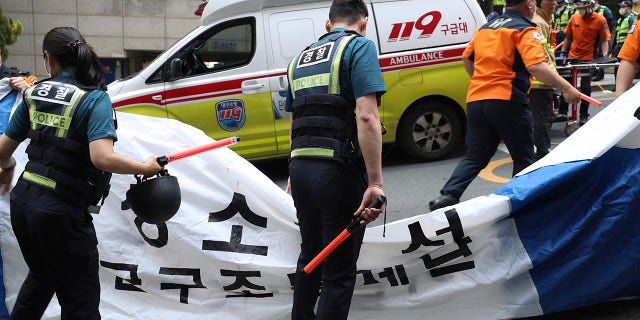 South Korean police officers and firefighters check around the scene of a fire in Daegu, South Korea, Thursday, June 9, 2022. Multiple people were killed and dozens of others were injured Thursday in the fire that spread through the office building in South Korea's Daegu city, local fire and police officials said. (Park Se-jin/Yonhap via AP)