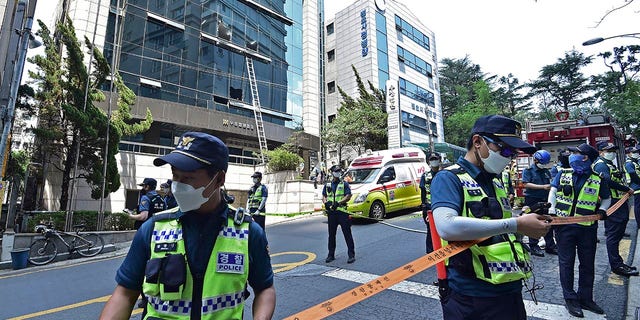 Ketvirtadienį, 2022 m. birželio 9 d., policijos pareigūnai kontroliuoja gaisro vietą Tegu mieste, Pietų Korėjoje. Keli žmonės žuvo ir dešimtys buvo sužeisti ketvirtadienį per gaisrą, kilusį biurų pastate Pietų Korėjos Degu mieste, vietiniame mieste. gaisras, pranešė policijos pareigūnai.  (Lee Mu-yeol / Naujienos per AP)