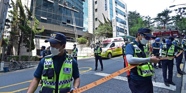 Police officers control the scene of a fire in Daegu, South Korea, Thursday, June 9, 2022. A number of people were killed and dozens of others injured Thursday in a fire that spread through an office building in South Korea's Daegu city, local fire and police officials said. (Lee Mu-yeol/Newsis via AP)