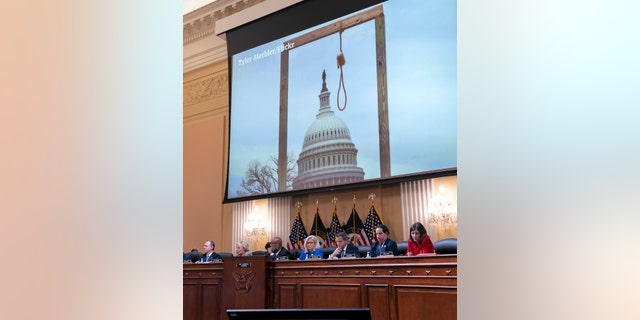 An image of a mock gallows on the grounds of the U.S. 1 월의 국회 의사당. 6, 2021,  is shown as committee members from left to right, Rep. 아담 쉬프, D-Calif., Rep. Zoe Lofgren, D- 칼리프., Chairman Bennie Thompson, 디-미스., Vice Chair Liz Cheney, R-Wyo., Rep. 아담 킨 �대표�, R-Ill., Rep. 제이미 라 스킨, D-Md., 및 담당자. 일레인 루리아, D-Go., look on, as the House select committee investigating the Jan. 6 미국에 대한 공격. Capitol holds its first public hearing to reveal the findings of a year-long investigation, 워싱턴의 국회 의사당에서, 목요일, 유월 9, 2022. 