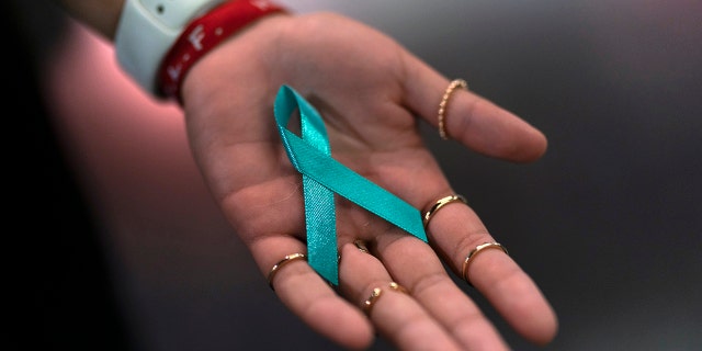 Sarah Barber shows a ribbon given to her by sexual abuse survivors at the Southern Baptist Convention’s annual meeting in Anaheim, Calif., Tuesday, June 14, 2022.