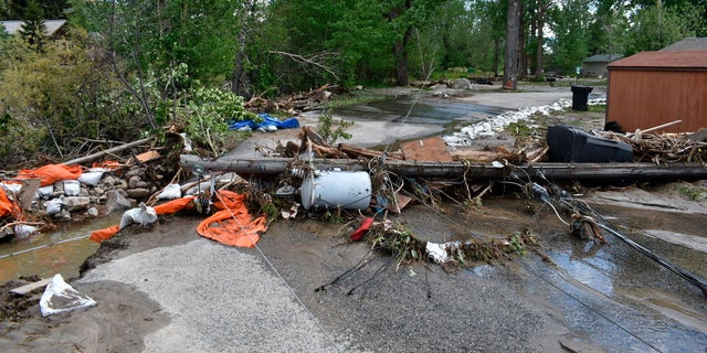 Debris is seen blocking a street in Red Lodge, Montana, on Tuesday, June 14, 2022, after floodwaters coursed through a neighborhood with hundreds of houses the day before. Residents were cleaning up after record floods in southern Montana this week. 
