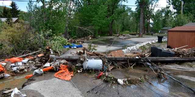 Debris is seen blocking a street in Red Lodge, Montana, on Tuesday, June 14, 2022, after floodwaters coursed through a neighborhood with hundreds of houses the day before. Residents were cleaning up after record floods in southern Montana this week. 