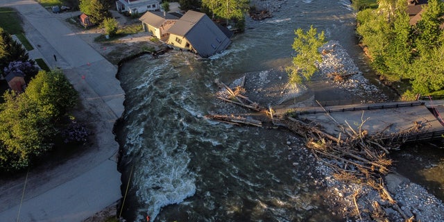 A house sits in Rock Creek after floodwaters washed away a road and a bridge in Red Lodge, Mont., Wednesday, June 15, 2022. 