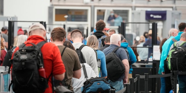 FILE - Travelers queue up at the north security checkpoint in the main terminal of Denver International Airport, Thursday, May 26, 2022, in Denver.  (AP Photo/David Zalubowski, File)