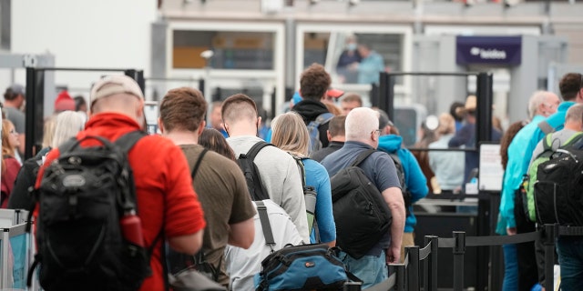 FILE - Travelers queue up at the north security checkpoint in the main terminal of Denver International Airport, Thursday, May 26, 2022, in Denver.  (AP Photo/David Zalubowski, File)