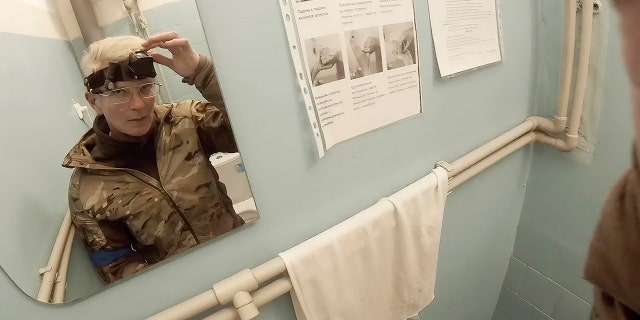 FILE - Yuliia Paievska, known as Taira, looks in a mirror and turns off her camera in Mariupol, Ukraine, on Feb. 27, 2022. (Yuliia Paievska via AP)