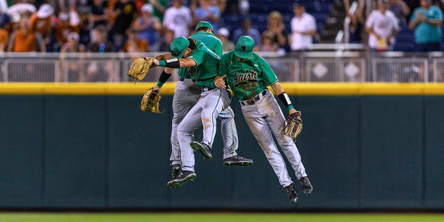Notre Dame outfielders Ryan Cole, Spencer Myers, and Brooks Coetzee celebrate the team's win over Texas in an NCAA College World Series baseball game Friday, 유월 17, 2022, in Omaha, Neb. 