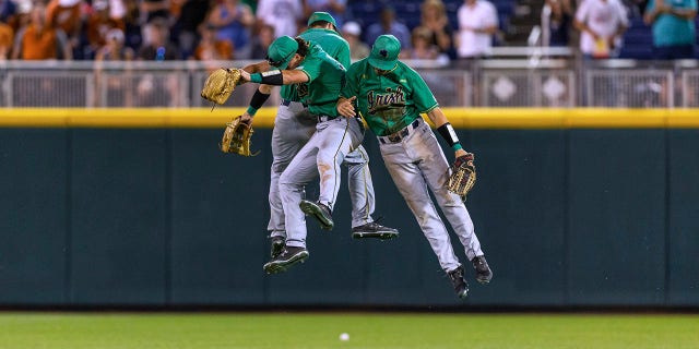 Notre Dame outfielders Ryan Cole, Spencer Myers, and Brooks Coetzee celebrate the team's win over Texas in an NCAA College World Series baseball game Friday, June 17, 2022, in Omaha, Neb. 