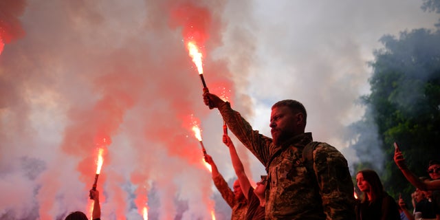 Soldiers hold rockets as they attend the funeral of activist and soldier Roman Ratushnyi in Kiev, Ukraine on June 18, 2022.