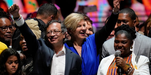 Former rebel Gustavo Petro, left, his wife Veronica Alcocer, back center, and his running mate Francia Marquez, celebrate before supporters after winning a runoff presidential election in Bogota, Colombia, Sunday, June 19, 2022. (AP Photo/Fernando Vergara)