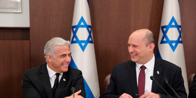 FILE - Israeli Prime Minister Naftali Bennett, right, and Foreign Minister Yair Lapid attend a cabinet meeting at the Prime Minister's office in Jerusalem, June 19, 2022. Bennett's office announced Monday, June 20, 2022, that his weakened coalition will be disbanded, and the country will head to new elections. Bennett and his main coalition partner, Yair Lapid, decided to present a vote to dissolve parliament in the coming days, Bennett's office said. Lapid is then to serve as caretaker prime minister. The election, expected in the fall, would be Israel's fifth in three years. (Abir Sultan/Pool Photo via AP, File)