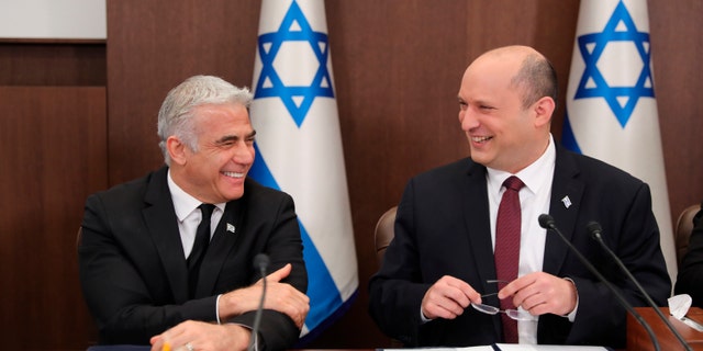 FILE - Israeli Prime Minister Naftali Bennett, right, and Foreign Minister Yair Lapid attend a cabinet meeting at the Prime Minister's office in Jerusalem, June 19, 2022. Bennett's office announced Monday, June 20, 2022, that his weakened coalition will be disbanded, and the country will head to new elections. Bennett and his main coalition partner, Yair Lapid, decided to present a vote to dissolve parliament in the coming days, Bennett's office said. Lapid is then to serve as caretaker prime minister. The election, expected in the fall, would be Israel's fifth in three years. (Abir Sultan/Pool Photo via AP, File)