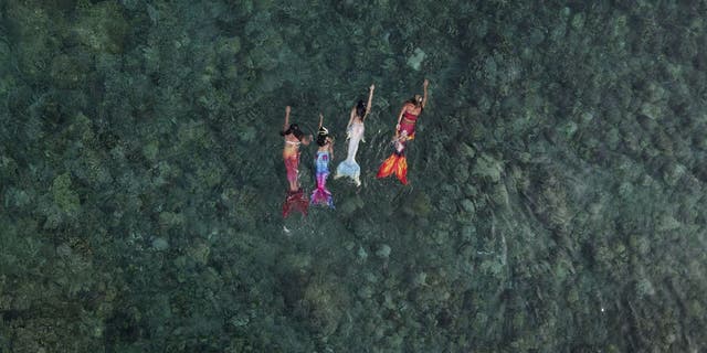 In this photo from May 22, 2022, Queen Pangke Tabora (far right) swims with mermaid students during a mermaid swim class in Mabini, Batangas province, Philippines.