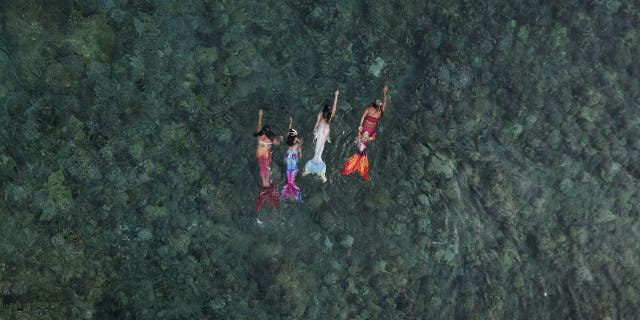 In this photo from May 22, 2022, Queen Pangke Tabora (far right) swims with mermaid students during a mermaid swim class in Mabini, Batangas province, Philippines.