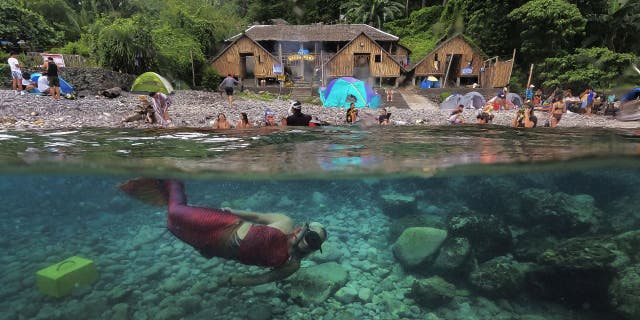 Queen Pangke Tabora swims in her mermaid tail in May 2022 while she conducts a mermaid swim demonstration in front of an Ocean Camp in Mabini, Batangas province, Philippines.