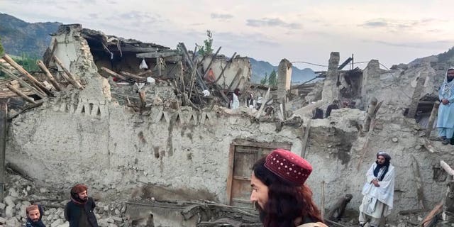 На этой фотографии, опубликованной государственным информационным агентством Bakhtar, афганцы смотрят на разрушения, вызванные землетрясением в провинции Пактика, восточный Афганистан, среда, 22 июня 2022 года.