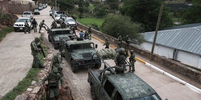 Mexican army vehicles arrive at Cerocahui, Mexico church following the murders.