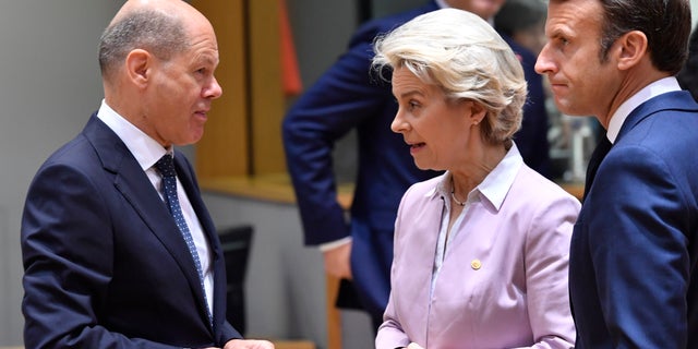 European Commission President Ursula von der Leyen, center, and French President Emmanuel Macron, right, speak with German Chancellor Olaf Scholz during a round table meeting at an EU summit in Brussels, Thursday, June 23, 2022. European Union leaders are expected to approve Thursday a proposal to grant Ukraine a EU candidate status, a first step on the long toward membership. The stalled enlargement process to include Western Balkans countries in the bloc is also on their agenda at the summit in Brussels. (AP Photo/Geert Vanden Wijngaert)