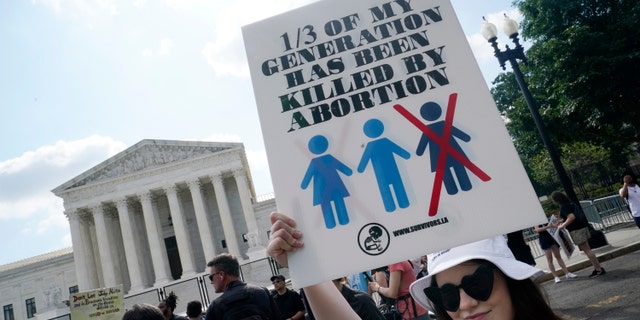 Faith Adams from Bangor, Maine, protests about abortion, Friday, June 24, 2022, outside the Supreme Court in Washington. (AP Photo/Steve Helber)